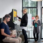 a group of people standing around a machine