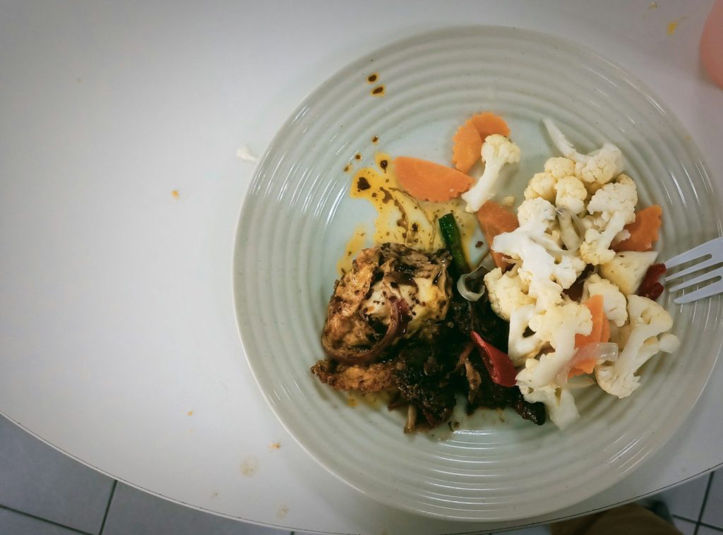 A white plate topped with meat and veggies