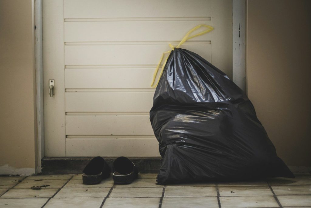 black plastic bag beside white wall