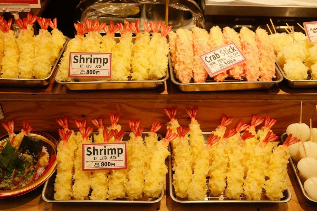 Fried shrimp tempura displayed on a market stall.