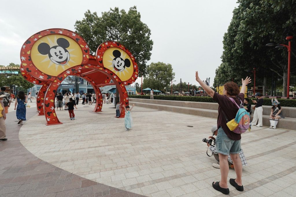 People gather near a large mickey mouse ears archway.