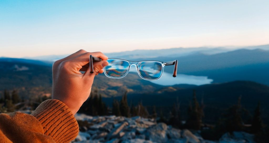 person holding silver framed eyeglasses