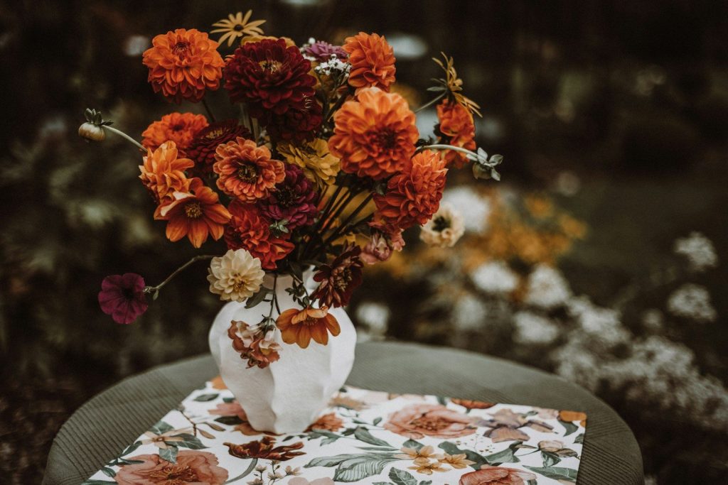Vase of colorful dahlias on a patterned cloth