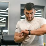 Man checking smartwatch in a gym.