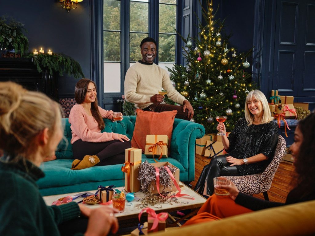 a group of people sitting around a christmas tree