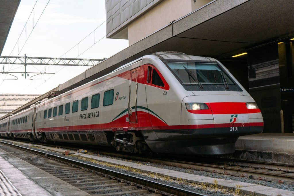 A modern red and white train at a station.
