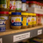 assorted plastic containers on brown wooden shelf