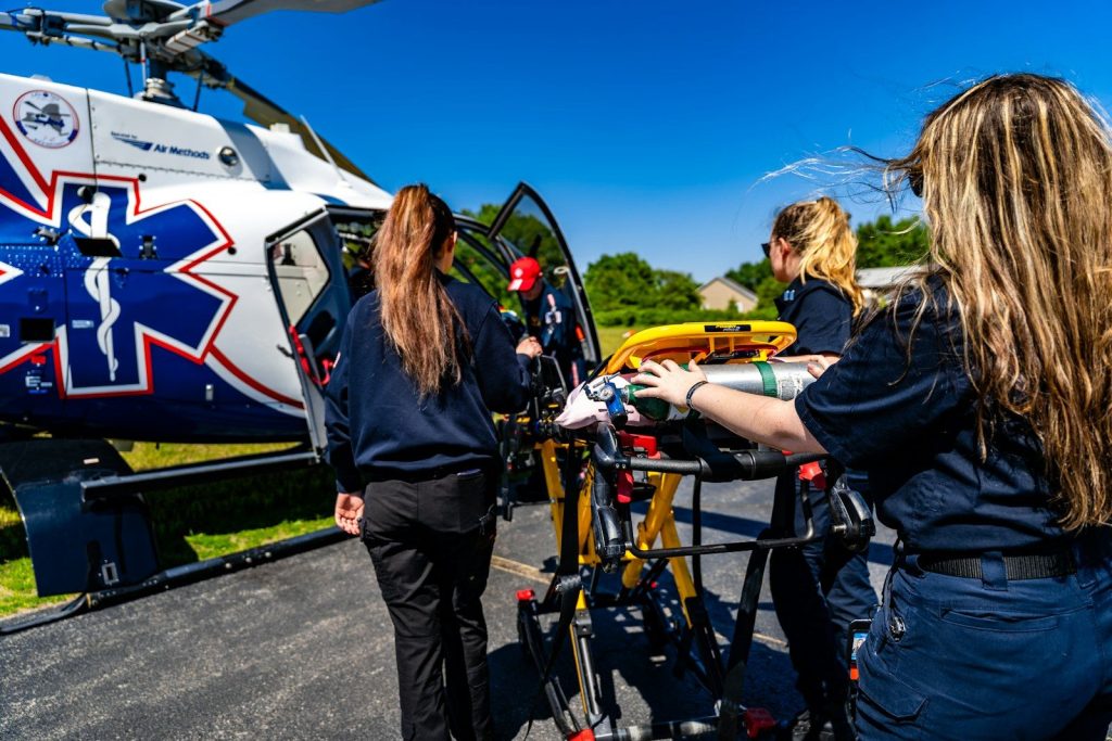 Medical personnel load a stretcher into an air ambulance helicopter.
