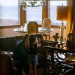 girl in black dress standing beside table
