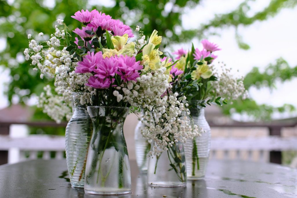 a couple of vases filled with flowers sitting on a table