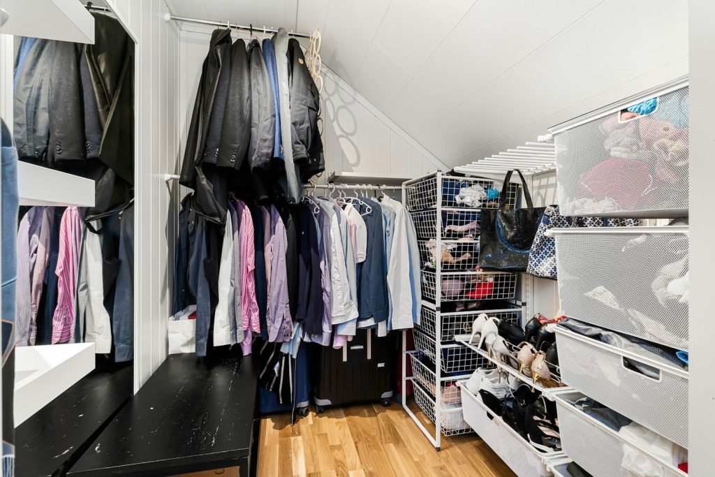 A walk in closet filled with lots of clothes